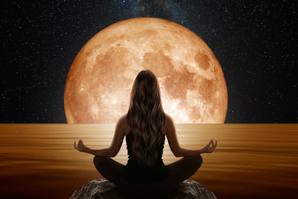 Frau meditiert, Vollmond im Hintergrund